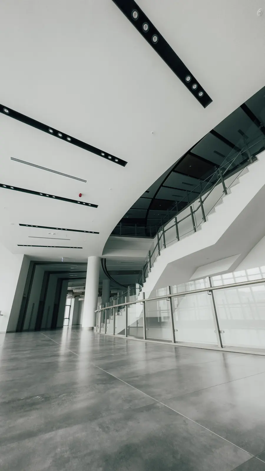 Jasny hol z przeszkleniami i szklanymi balustradami